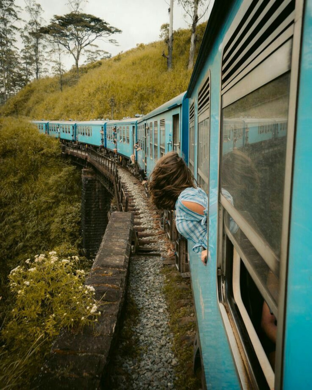 Blue train travelling through Sri Lanka's hill country