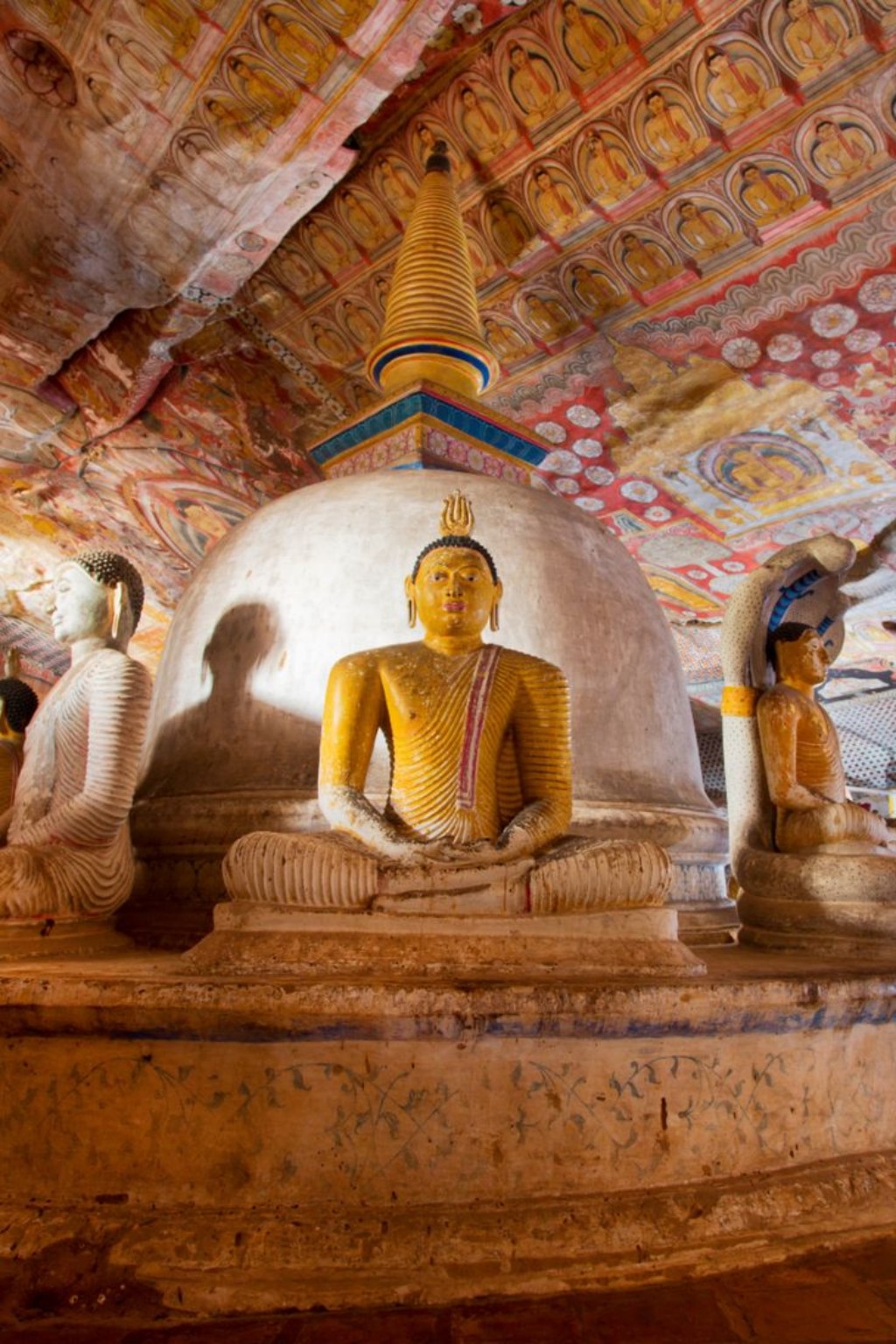Buddha statue and painted ceiling inside Dambulla Cave Temple